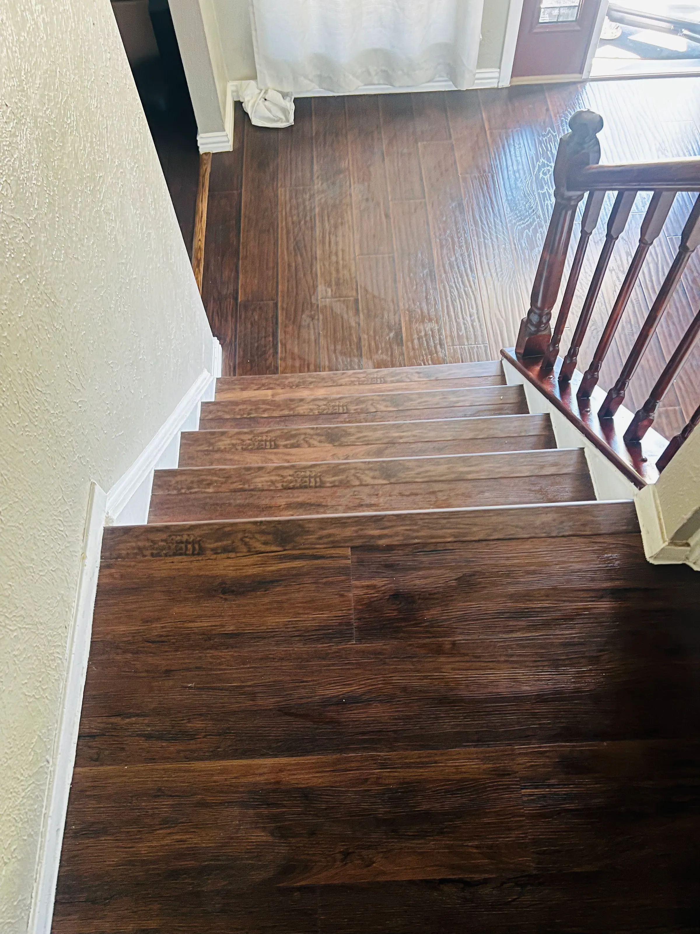 Vista hacia abajo del tramo inferior, con balaustres de madera a la derecha y huellas de LVP hasta el piso principal.